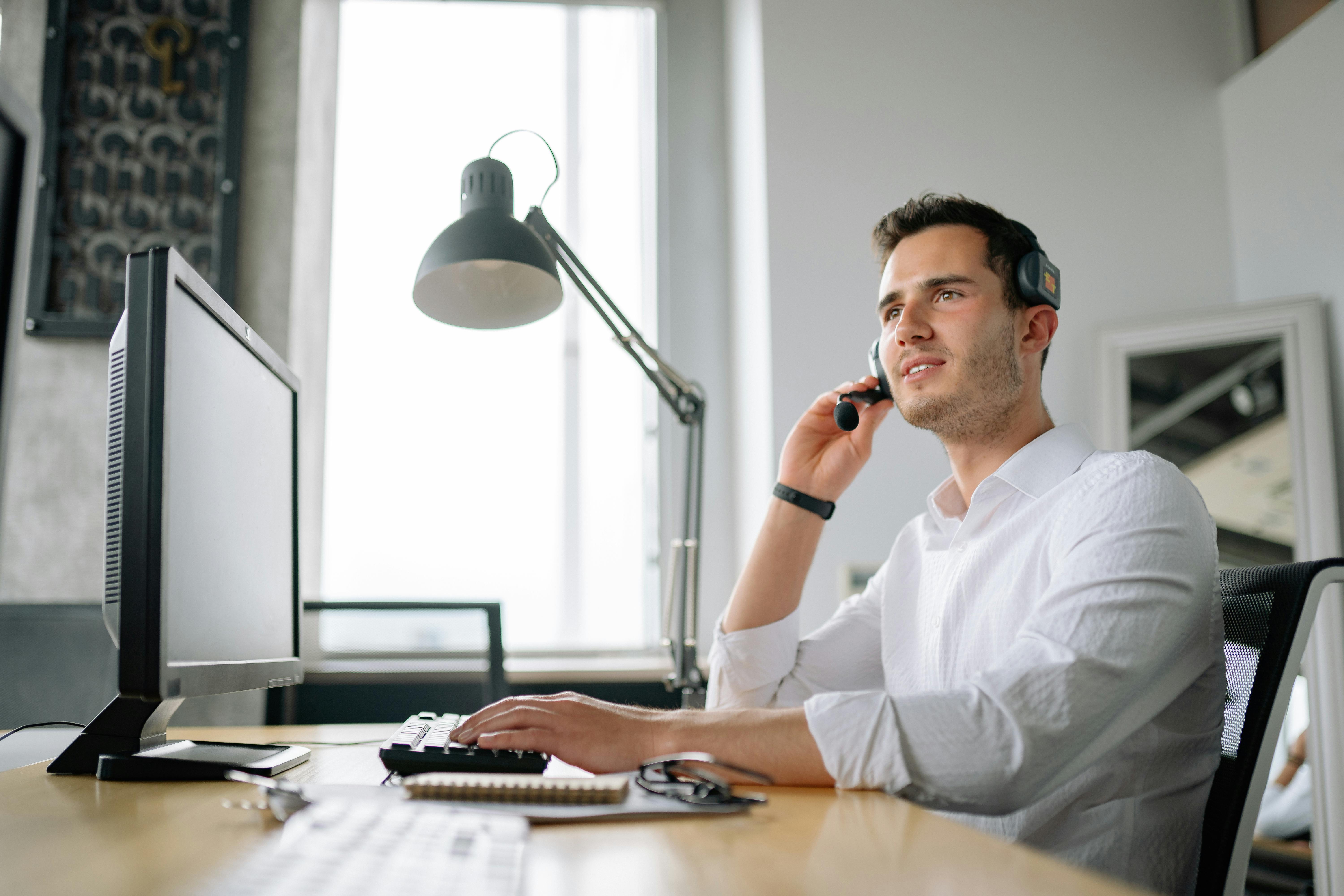 A technical support agent answering a customer call on his headset